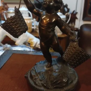 delizioso statuina di putto in antimonio con cestini